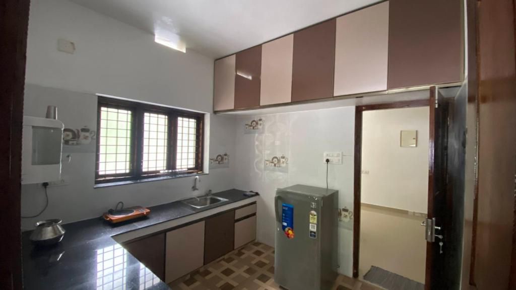 Kitchen with cabinets, sink and refrigerator.
