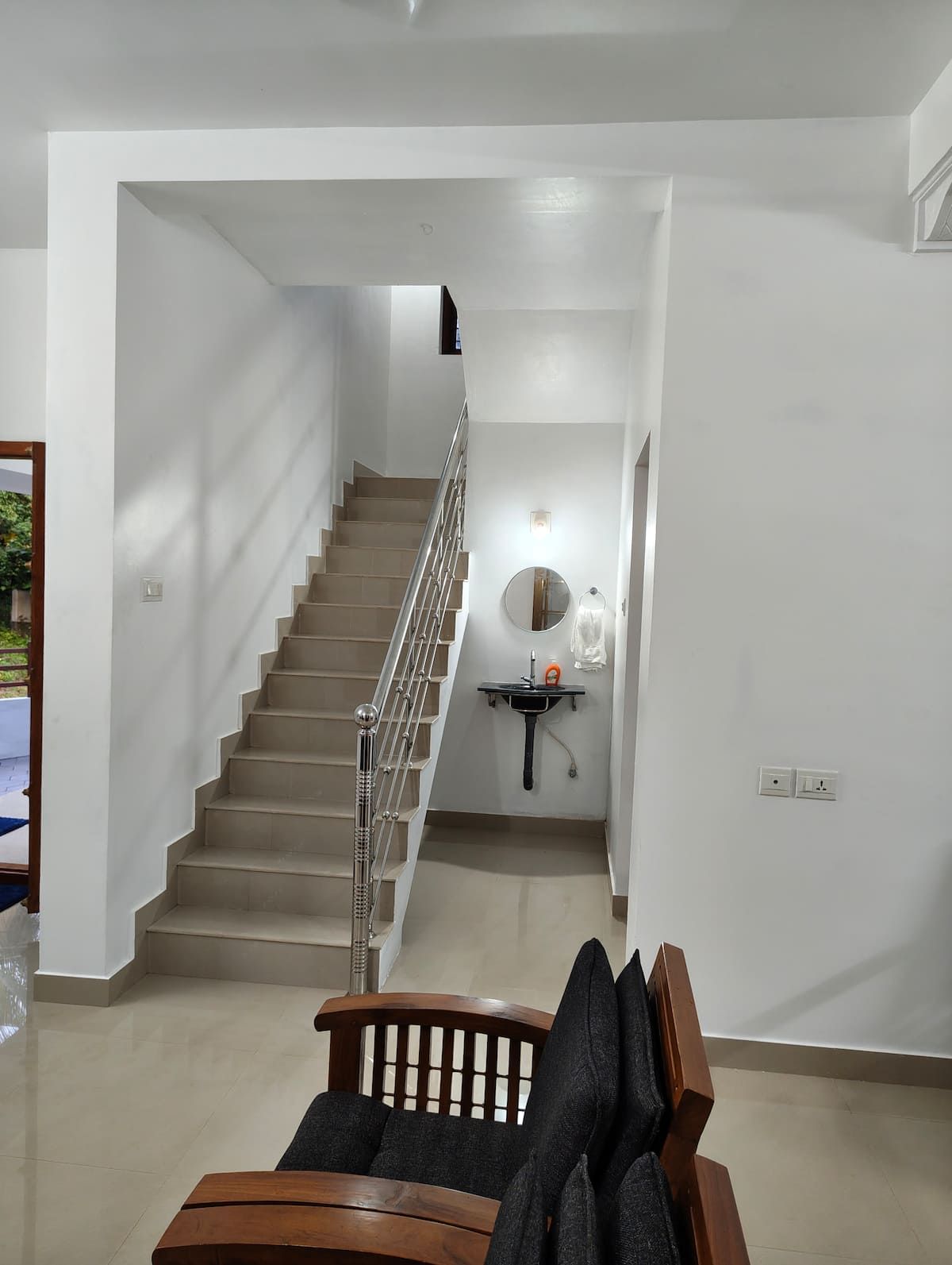 Indoor staircase and hall with a sofa and wash basin.