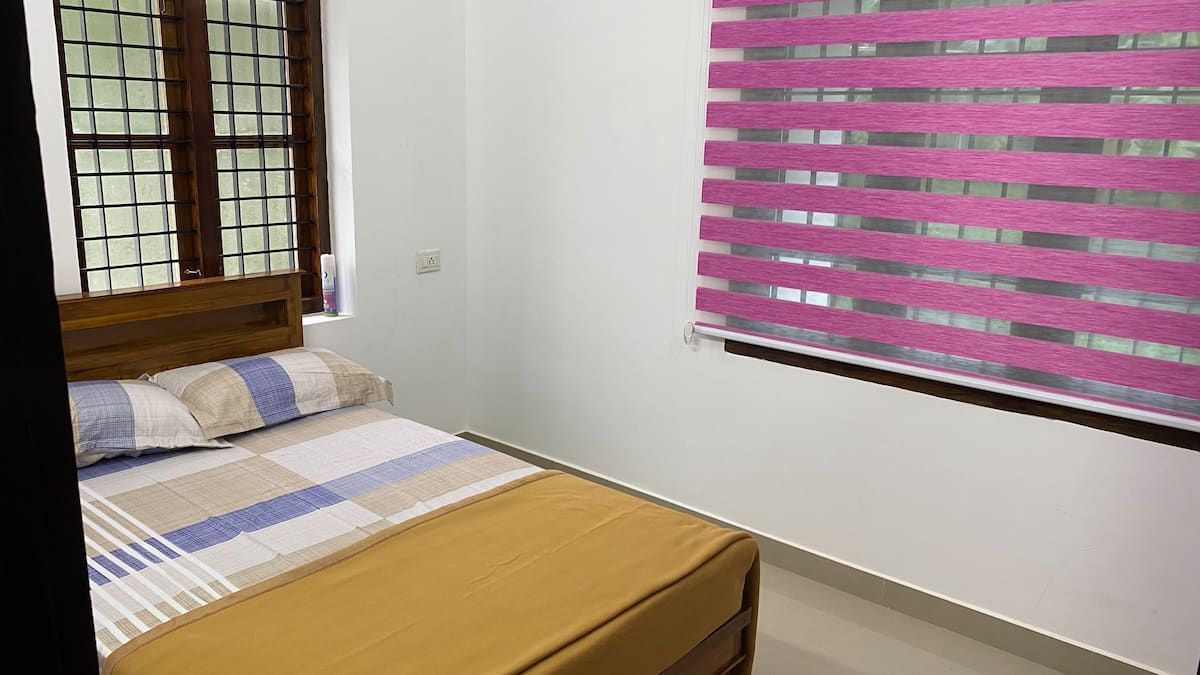 Studio bedroom with a double bed and striped bedding.